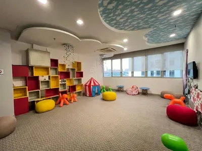 a room with a classroom with colorful chairs and shelves at Empire Hostel Regalia in Kuala Lumpur