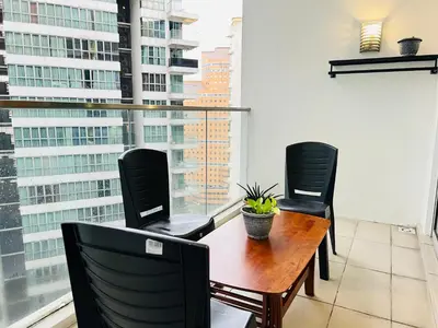 a balcony with a table and chairs and a window at Empire Hostel Regalia in Kuala Lumpur