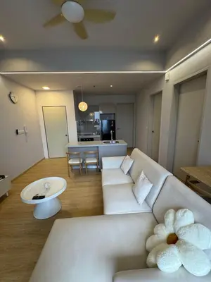 a living room with a white couch and a table at trion kl TRX klcc view in Kuala Lumpur
