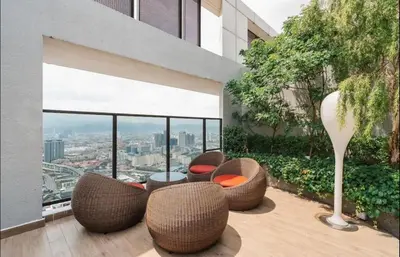 a balcony with chairs and a table on a building at trion kl TRX klcc view in Kuala Lumpur