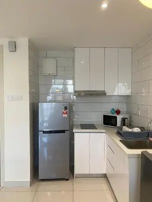 a kitchen with white cabinets and a stainless steel refrigerator at Duplex Arte Mont Kiara modern design nice view in Kuala Lumpur