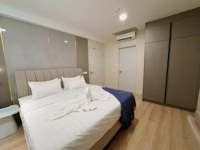a bedroom with a large bed with white clothes on it at The Atrium at Jalan Ampang by OKBnB - Modern Stylish 2Bedroom with FREE WiFi and Carpark in Kuala Lumpur