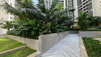 a concrete retaining wall with plants and palm trees at MH Platinum 2 COZY Fully Air-Con Suite Kuala Lumpur in Kuala Lumpur