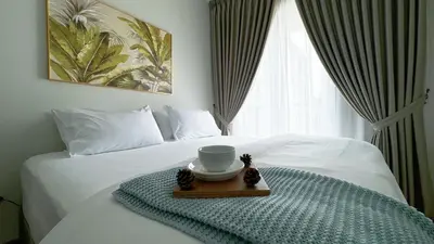 a bed with a tray with a cup on it at MH Platinum 2 COZY Fully Air-Con Suite Kuala Lumpur in Kuala Lumpur