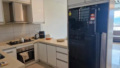 a kitchen with a black refrigerator in a kitchen at Zetapak homestay in Kuala Lumpur