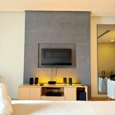 a living room with a tv on a wall at 188 Suites KLCC Hotel with bathtub in KL in Kuala Lumpur