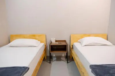 two twin beds in a room with a night stand at Pak Fook Hotel Chow Kit in Kuala Lumpur