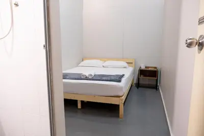 a small bedroom with a bed and a shower at Pak Fook Hotel Chow Kit in Kuala Lumpur