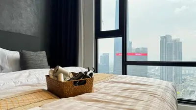 a bedroom with a bed with a view of a city at Just Stay Axon Residence Suite Bukit Bintang in Kuala Lumpur