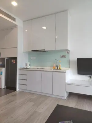 a white kitchen with white cabinets and a tv at 1Bukit ceylon view 118 in Kuala Lumpur