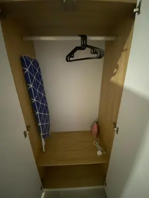 a small closet with a wooden shelf and a hanger at KL City, Neu Suites 2Bedroom 1Bathroom in Kuala Lumpur