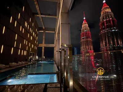 a view of the petronas twin towers at night at Luxury Tropicana The Residence SkyPool KlccView CityCenter By HeyStay Management in Kuala Lumpur