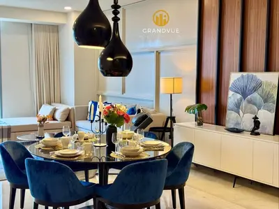 a dining room with a table and blue chairs at Luxury Tropicana The Residence SkyPool KlccView CityCenter By HeyStay Management in Kuala Lumpur