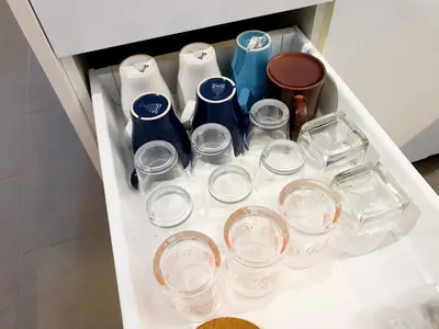 a drawer filled with clear glasses and other items at The Establisment KL Sentral by GBS in Kuala Lumpur