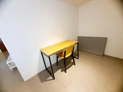 a wooden table and a yellow chair in a room at The Establisment KL Sentral by GBS in Kuala Lumpur