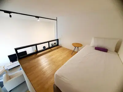 a bedroom with a white bed and a wooden floor at The Establisment KL Sentral by GBS in Kuala Lumpur