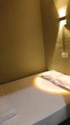 a small room with a bed with a light on it at Health Homestay KL in Kuala Lumpur