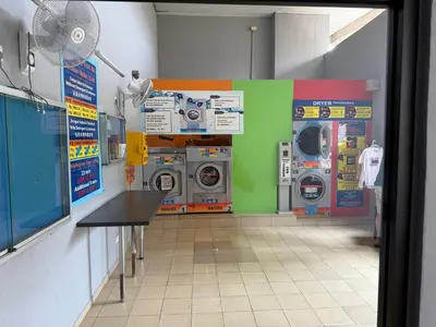 a laundry room with washing machines and a fan at Cosy Studio Apartment at Hartamas in Kuala Lumpur