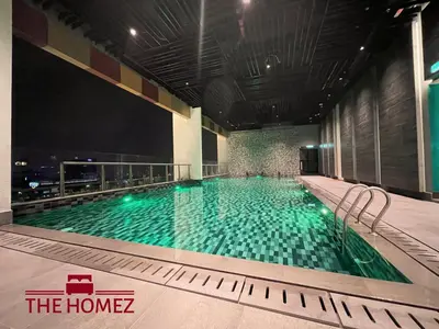 a large swimming pool with green water in a building at Alfa Bangsar by The Homez in Kuala Lumpur