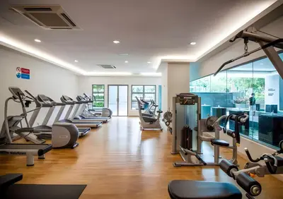 a gym with a row of treadmills and ellipticals at Suasana Bukit Ceylon by Goldcrests Global in Kuala Lumpur