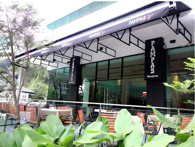 a restaurant with tables and chairs in front of a building at Suasana Bukit Ceylon by Goldcrests Global in Kuala Lumpur