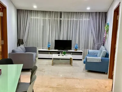 a living room with two blue chairs and a television at Vortex Suites By Asian in Kuala Lumpur