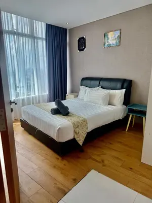 a bedroom with a large bed with a black headboard at Vortex Suites By Asian in Kuala Lumpur
