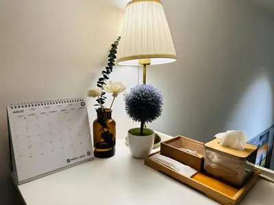 a desk with a calendar and a lamp and flowers at The Establishment LOFT Bangsar KL Sentral by \u54c1\u5c4b PINWU Shortstay in Kuala Lumpur