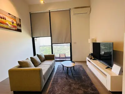 a living room with a couch and a tv at The Establishment LOFT Bangsar KL Sentral by \u54c1\u5c4b PINWU Shortstay in Kuala Lumpur