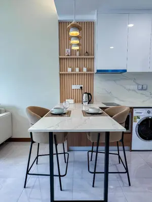 a kitchen with a white table and chairs at Core Residence at TRX by LL in Kuala Lumpur