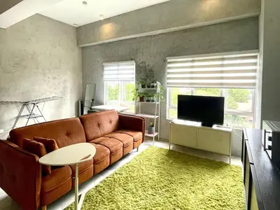 a living room with a brown couch and a television at 2 Bedroom Apartment l City View in Kuala Lumpur
