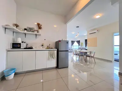 a kitchen with a refrigerator and a table with chairs at Arte Plus Ampang By Comfortstay in Kuala Lumpur