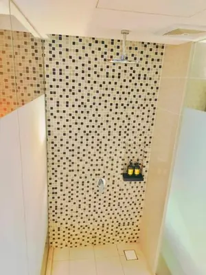 a bathroom with a shower with a black and white tiled wall at Oneiro D'Majestic place Klcc in Kuala Lumpur