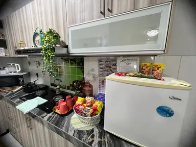 a kitchen with a refrigerator with a microwave above it at AS Homes Kuala Lumpur in Kuala Lumpur