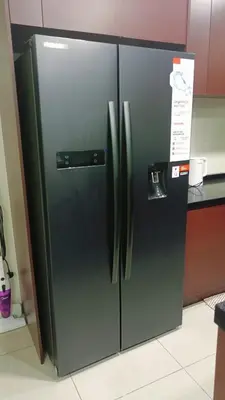 a black refrigerator in a kitchen with a sign on it at Twin Tower View Homestay Kuala Lumpur in Kuala Lumpur