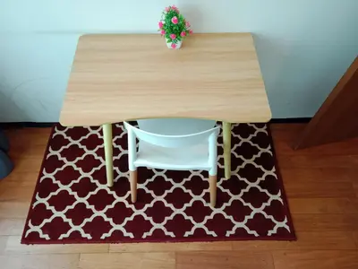 a wooden table with a white chair sitting under it at Vortex Suites KLCC By Farysha in Kuala Lumpur