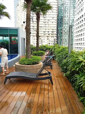 a deck with benches and palm trees in a city at Vortex Suites KLCC By Farysha in Kuala Lumpur