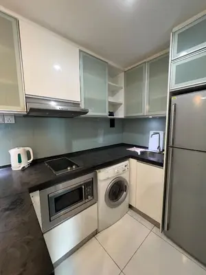 a kitchen with white cabinets and a washer and dryer at Casa Residency in Bukit in Kuala Lumpur