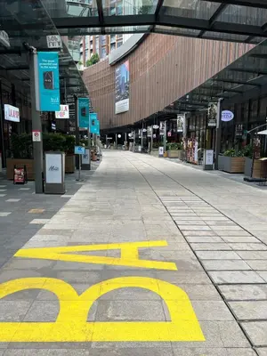 an empty shopping mall with a yellow sign on the ground at Near Jalan Alor in Kuala Lumpur