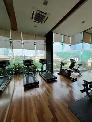 a gym with several cardio machines in a room with windows at Comfy place near Bukit in Kuala Lumpur