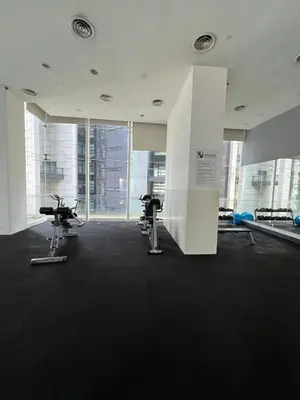 a gym with two exercise bikes in a room with windows at Convenient KLCC 2-Bedroom Unit in Kuala Lumpur
