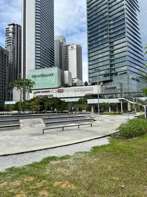 a park with benches in a city with tall buildings at Convenient KLCC 2-Bedroom Unit in Kuala Lumpur