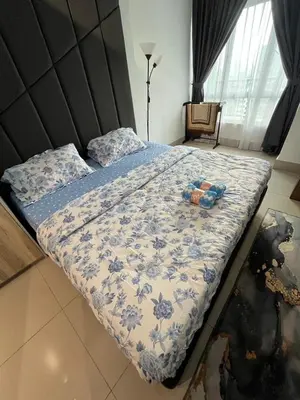 a bed with a blue and white comforter on it at Ayuanura Homestay in Kuala Lumpur