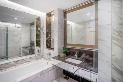 a bathroom with a tub and a sink and a mirror at Dorsett Residences Sri Hartamas, Mont Kiara Kuala Lumpur in Kuala Lumpur