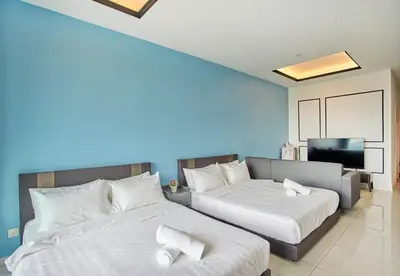 a bedroom with two beds and a television in it at Dorsett Residences Sri Hartamas, Mont Kiara Kuala Lumpur in Kuala Lumpur