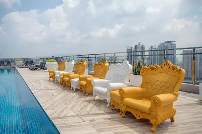 a row of yellow and white chairs next to a pool at Dorsett Residences Sri Hartamas, Mont Kiara Kuala Lumpur in Kuala Lumpur