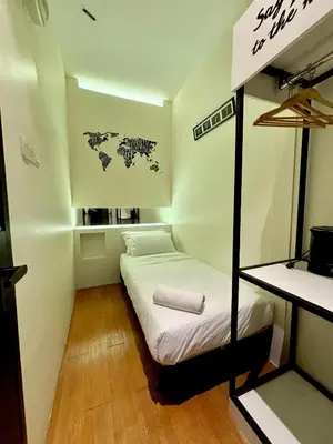 a small room with a bed with a map on the wall at Star Mews Hotel Changkat Bukit Bintang in Kuala Lumpur