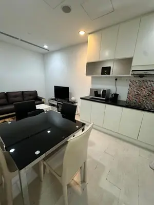 a living room with a table and chairs and a kitchen at Convenient KLCC in Kuala Lumpur