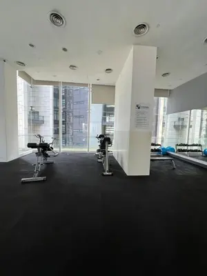 a gym with two exercise bikes in a room with windows at Convenient KLCC in Kuala Lumpur