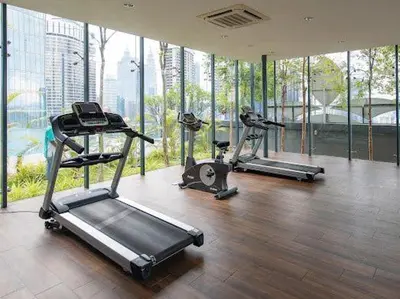 a gym with three tread machines in a room with windows at Dorsett Residence TRX KLCC #25 in Kuala Lumpur